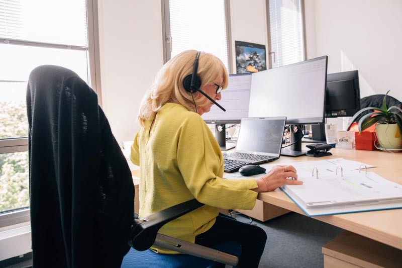 Frau mit Headset am Arbeitsplatz